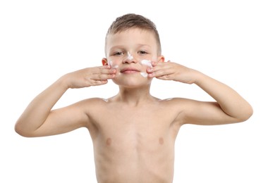 Photo of Little boy applying sun protection cream onto his skin on white background