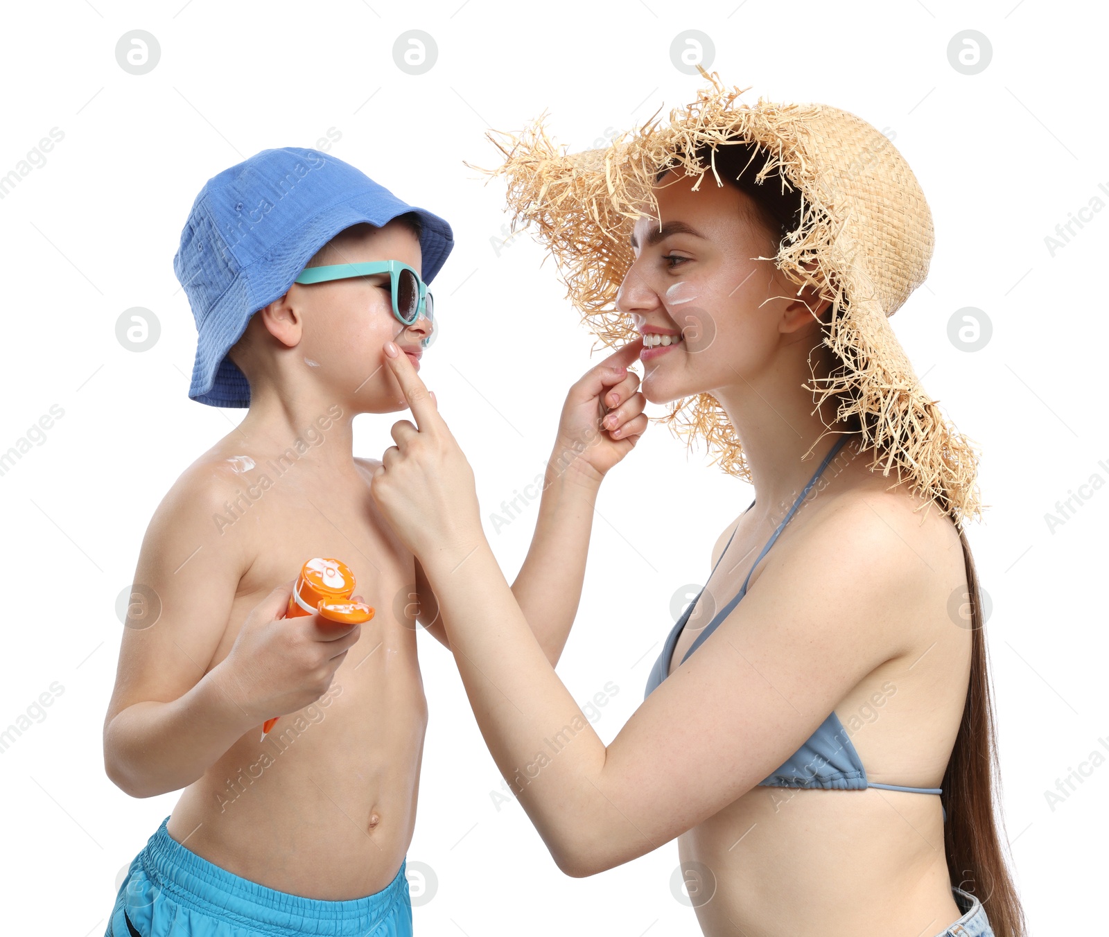 Mother and her son applying sun protection cream onto each other's skin on white background Photo of Mother and her son applying sun protection cream onto each other's skin on white background