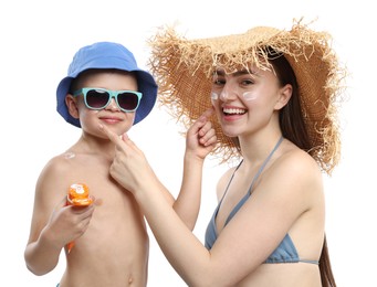 Photo of Mother and her son applying sun protection cream onto each other's skin on white background