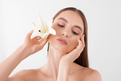 Photo of Portrait of attractive young woman with flower on white background