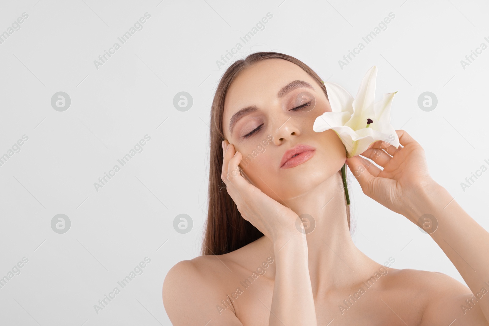 Portrait of attractive young woman with flower on white background. Space for text Photo of Portrait of attractive young woman with flower on white background. Space for text
