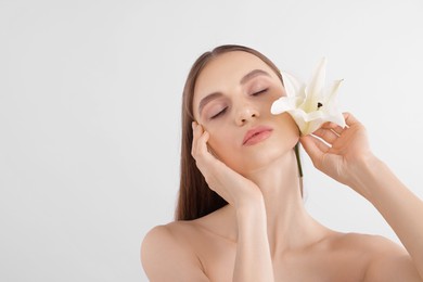 Photo of Portrait of attractive young woman with flower on white background. Space for text
