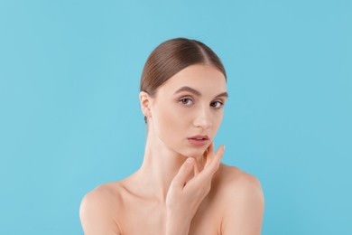 Photo of Portrait of charming young woman on light blue background