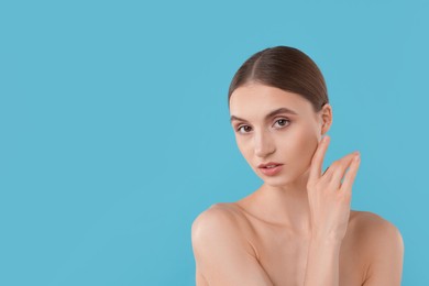 Photo of Portrait of charming young woman on light blue background. Space for text