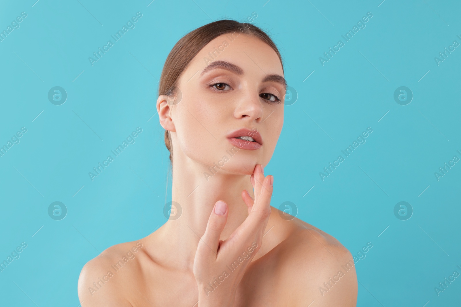 Portrait of charming young woman on light blue background Photo of Portrait of charming young woman on light blue background