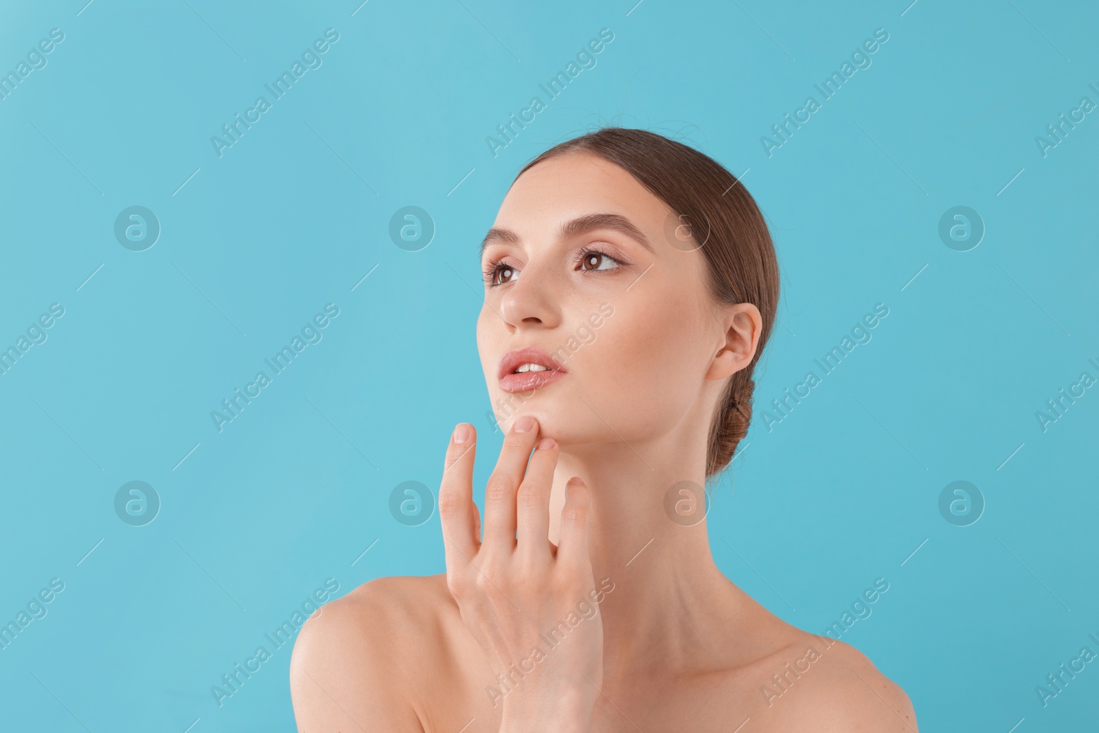 Portrait of charming young woman on light blue background Photo of Portrait of charming young woman on light blue background
