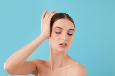 Photo of Portrait of charming young woman on light blue background