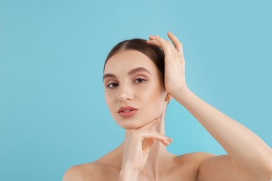 Photo of Portrait of charming young woman on light blue background