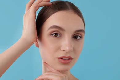 Photo of Portrait of charming young woman on light blue background