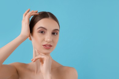 Photo of Portrait of charming young woman on light blue background. Space for text
