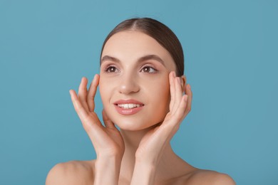 Photo of Portrait of charming young woman on light blue background