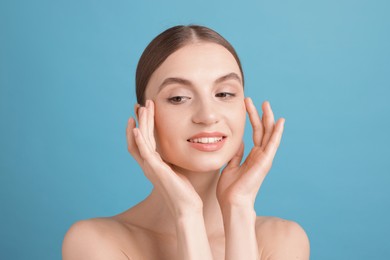 Photo of Portrait of charming young woman on light blue background