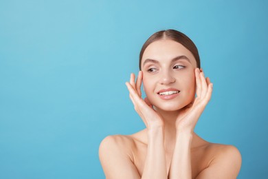 Photo of Portrait of charming young woman on light blue background. Space for text