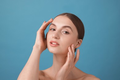 Photo of Portrait of charming young woman on light blue background