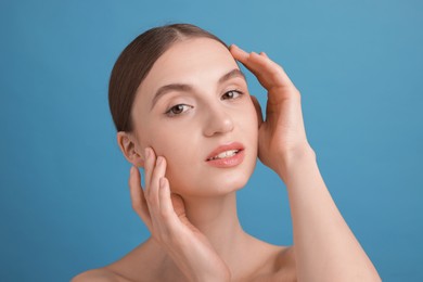 Photo of Portrait of charming young woman on light blue background