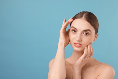 Photo of Portrait of charming young woman on light blue background. Space for text