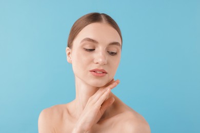 Photo of Portrait of charming young woman on light blue background