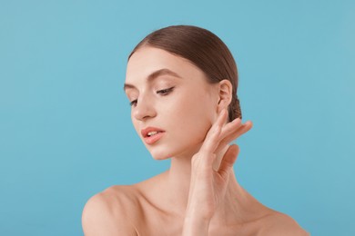 Photo of Portrait of charming young woman on light blue background