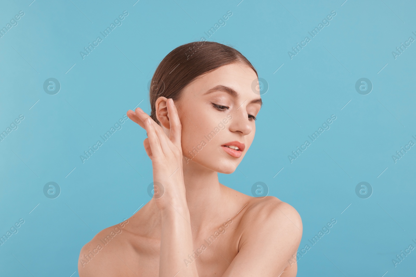 Portrait of charming young woman on light blue background Photo of Portrait of charming young woman on light blue background