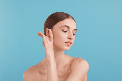 Photo of Portrait of charming young woman on light blue background