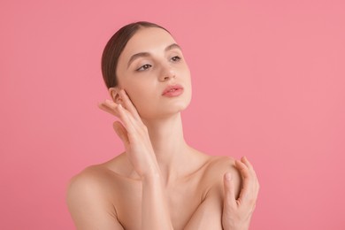 Photo of Portrait of beautiful young woman on pink background