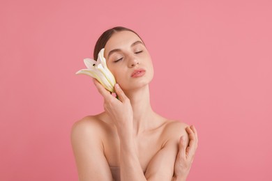 Photo of Portrait of beautiful young woman with flower on pink background