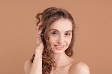 Photo of Portrait of beautiful young woman on beige background
