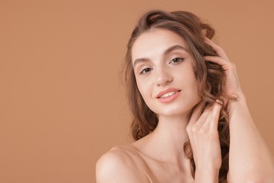 Photo of Portrait of beautiful young woman on beige background. Space for text