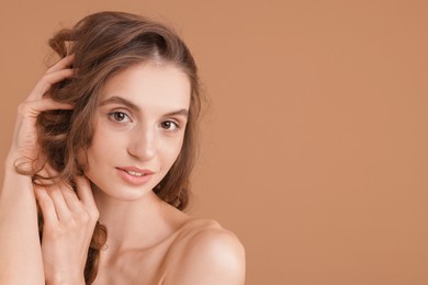 Photo of Portrait of beautiful young woman on beige background. Space for text