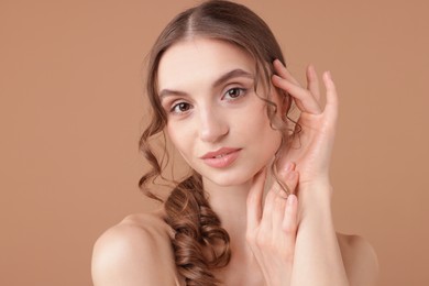 Photo of Portrait of beautiful young woman on beige background