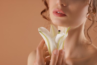 Photo of Beautiful woman with flower on beige background, closeup. Space for text
