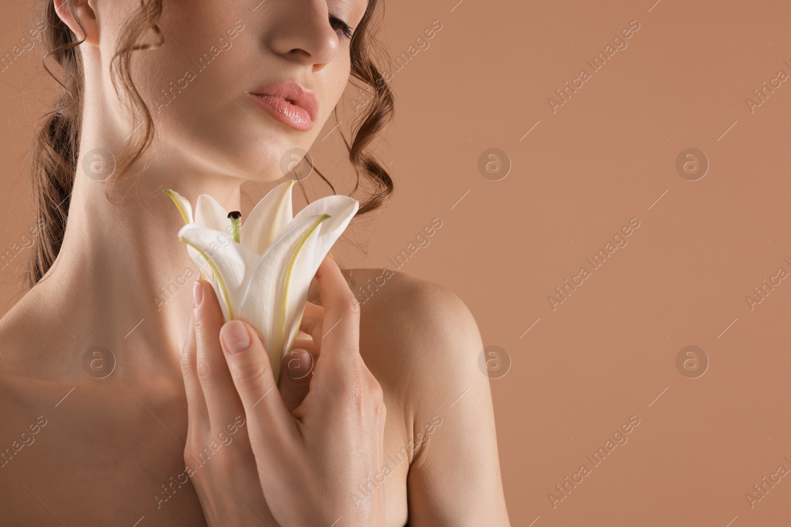 Portrait of beautiful young woman with flower on beige background, closeup. Space for text Photo of Portrait of beautiful young woman with flower on beige background, closeup. Space for text