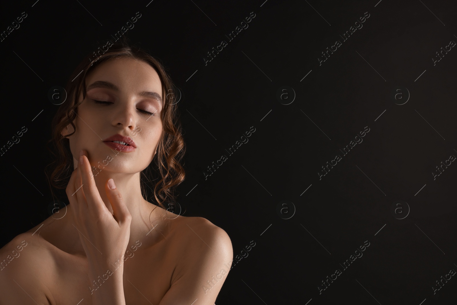 Portrait of gorgeous young woman on black background. Space for text Photo of Portrait of gorgeous young woman on black background. Space for text