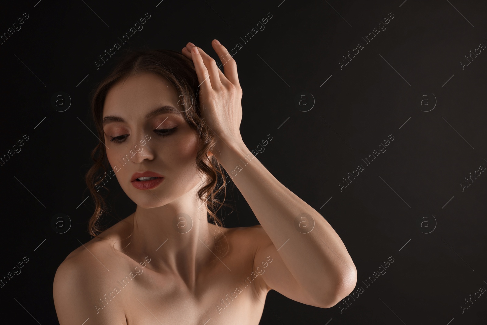 Portrait of gorgeous young woman on black background. Space for text Photo of Portrait of gorgeous young woman on black background. Space for text