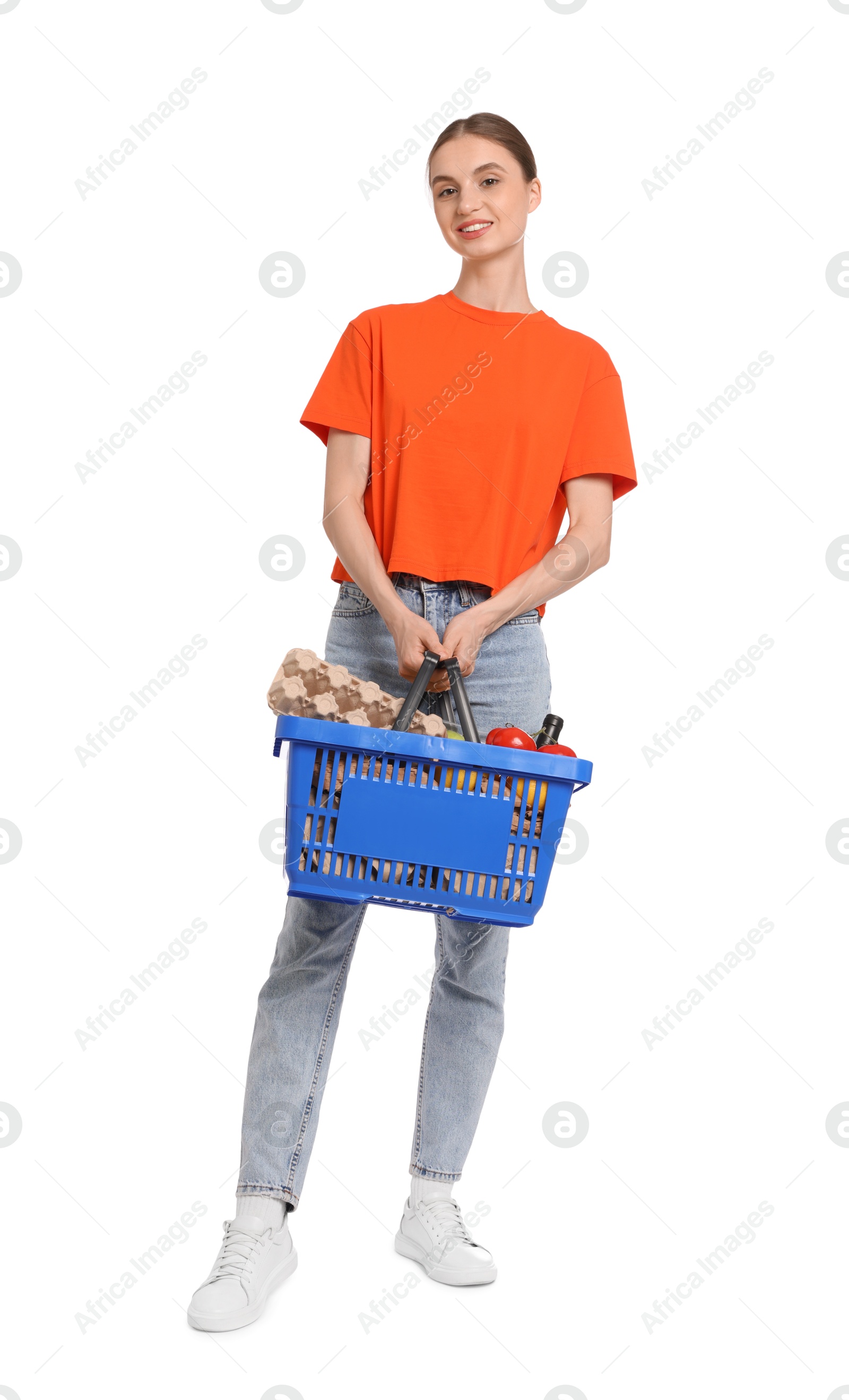 Woman with shopping basket full of products on white background Photo of Woman with shopping basket full of products on white background
