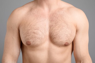 Photo of Young man with hairy chest on light grey background, closeup. Epilation procedure