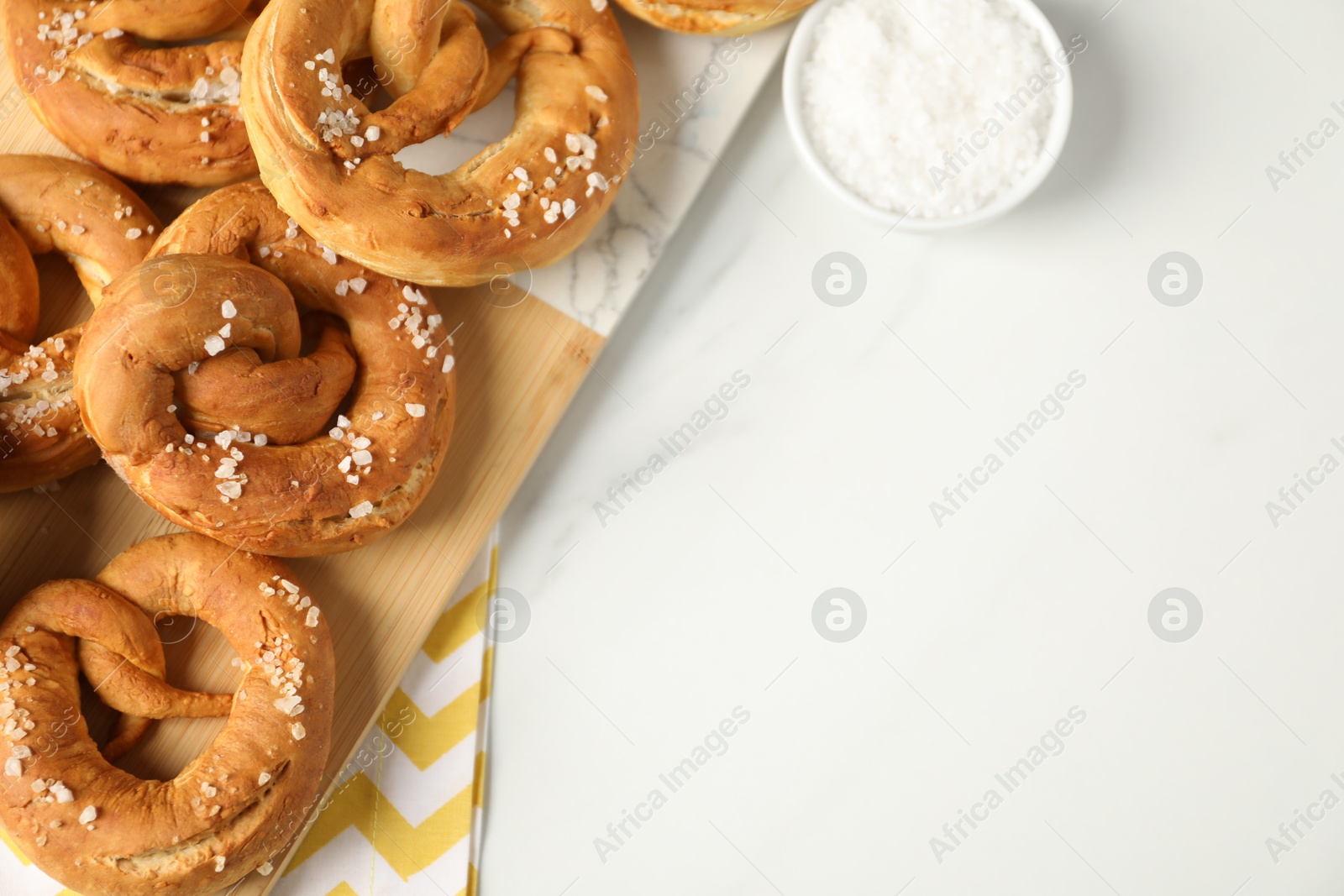 Tasty pretzels with salt on white marble table, flat lay. Space for text Photo of Tasty pretzels with salt on white marble table, flat lay. Space for text
