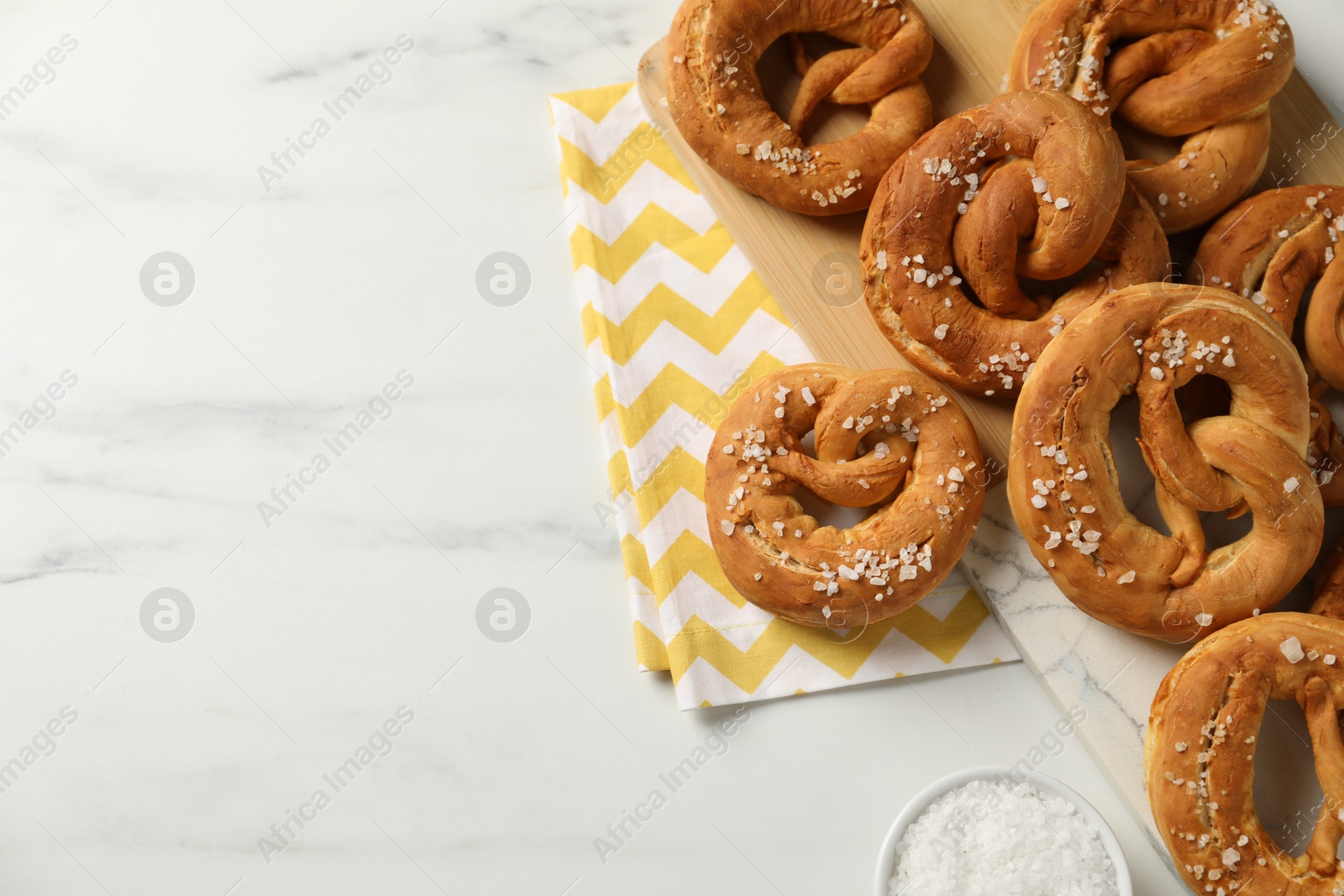 Tasty pretzels with salt on white marble table, flat lay. Space for text Photo of Tasty pretzels with salt on white marble table, flat lay. Space for text