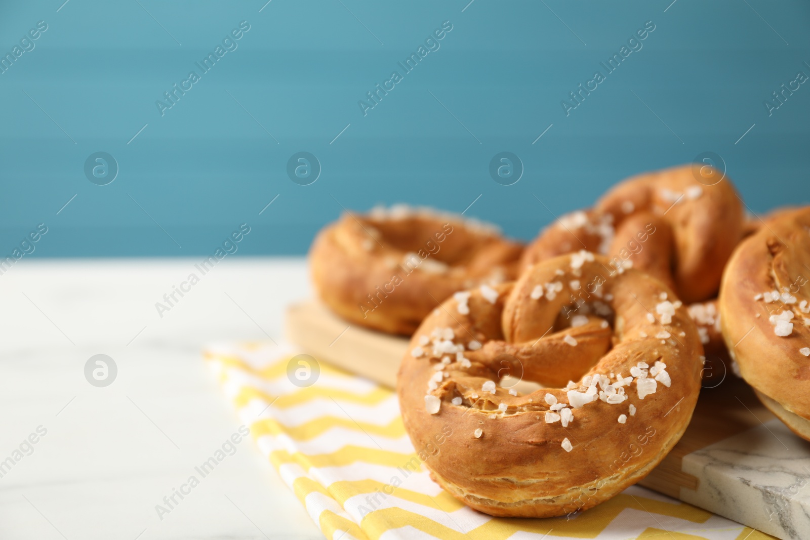 Tasty pretzels with salt on white table, closeup. Space for text Photo of Tasty pretzels with salt on white table, closeup. Space for text