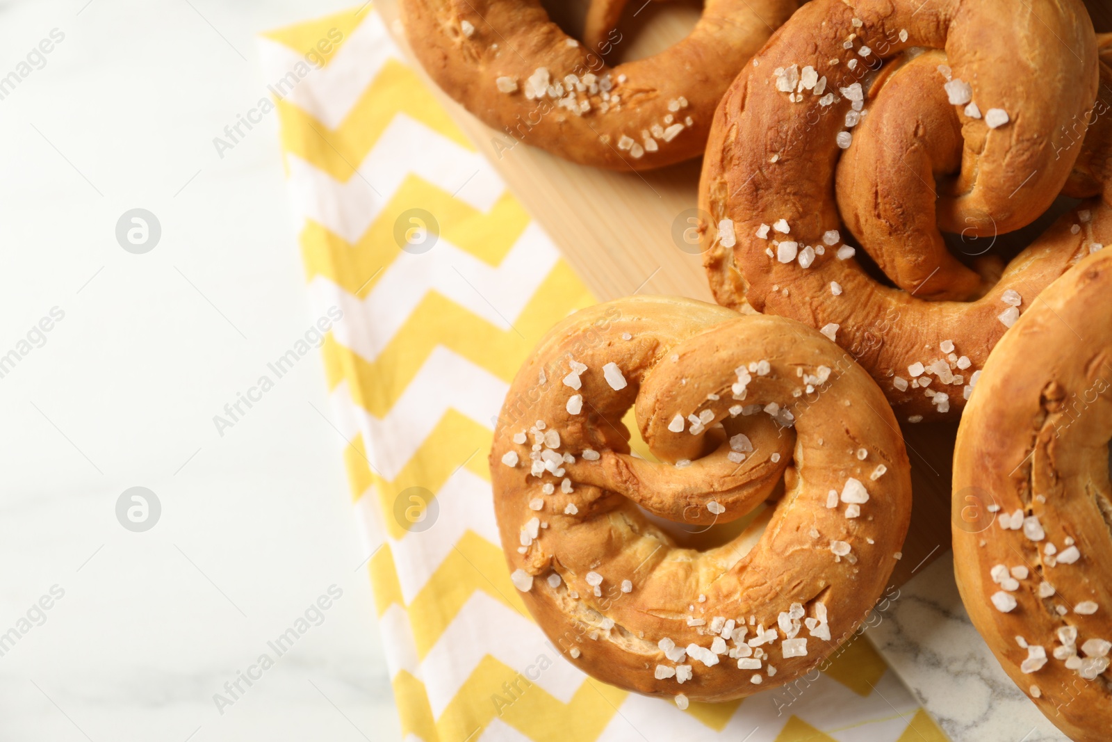 Tasty pretzels with salt on white table, above view. Space for text Photo of Tasty pretzels with salt on white table, above view. Space for text