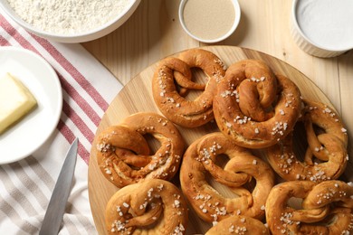 Photo of Tasty pretzels and ingredients on wooden table, flat lay