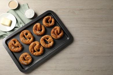 Photo of Tasty pretzels and ingredients on wooden table, flat lay. Space for text