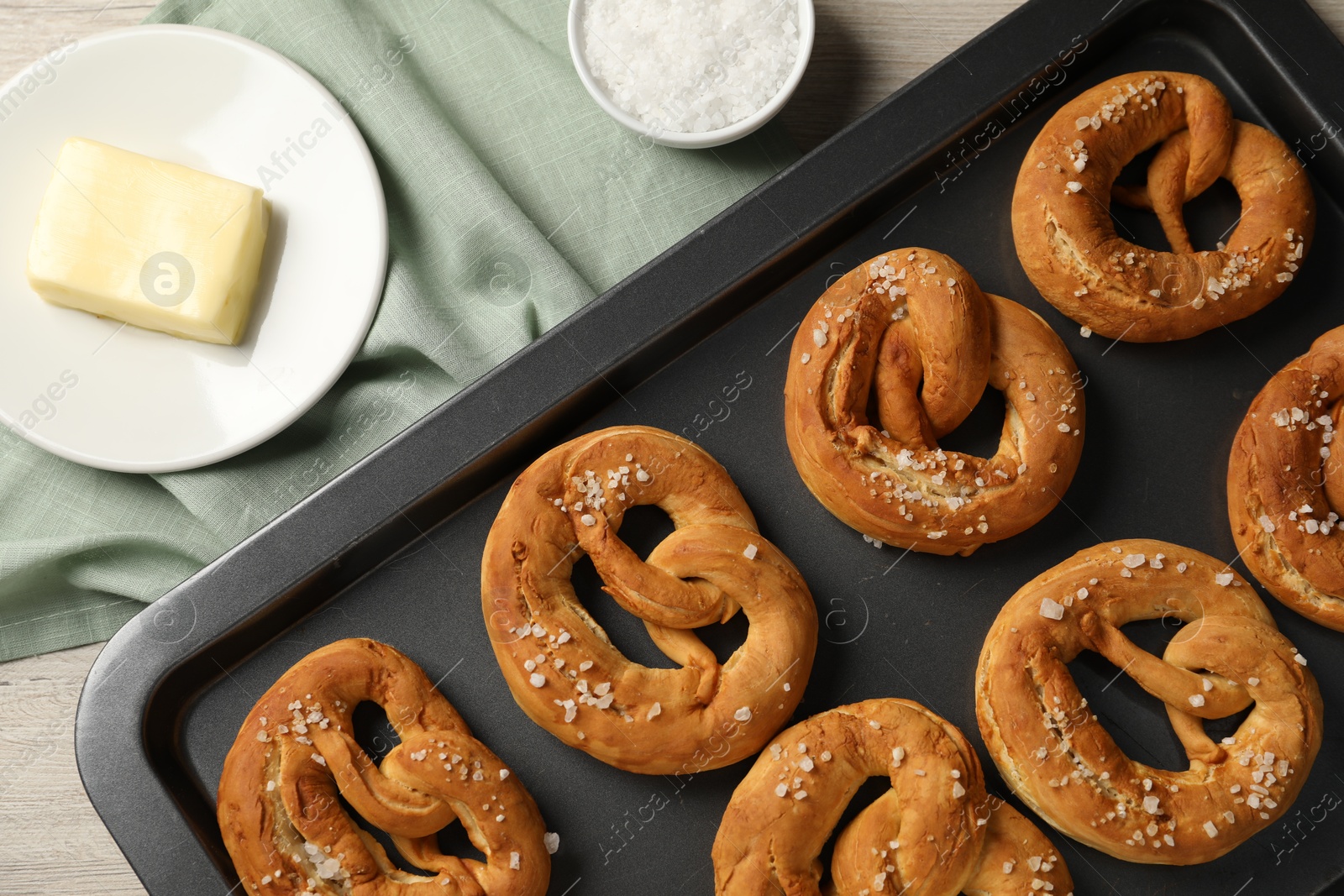 Tasty pretzels and ingredients on table, flat lay Photo of Tasty pretzels and ingredients on table, flat lay