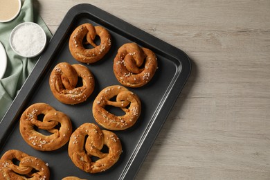 Photo of Tasty pretzels and ingredients on wooden table, flat lay. Space for text