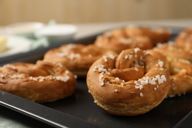 Photo of Tasty pretzels with salt on table, closeup