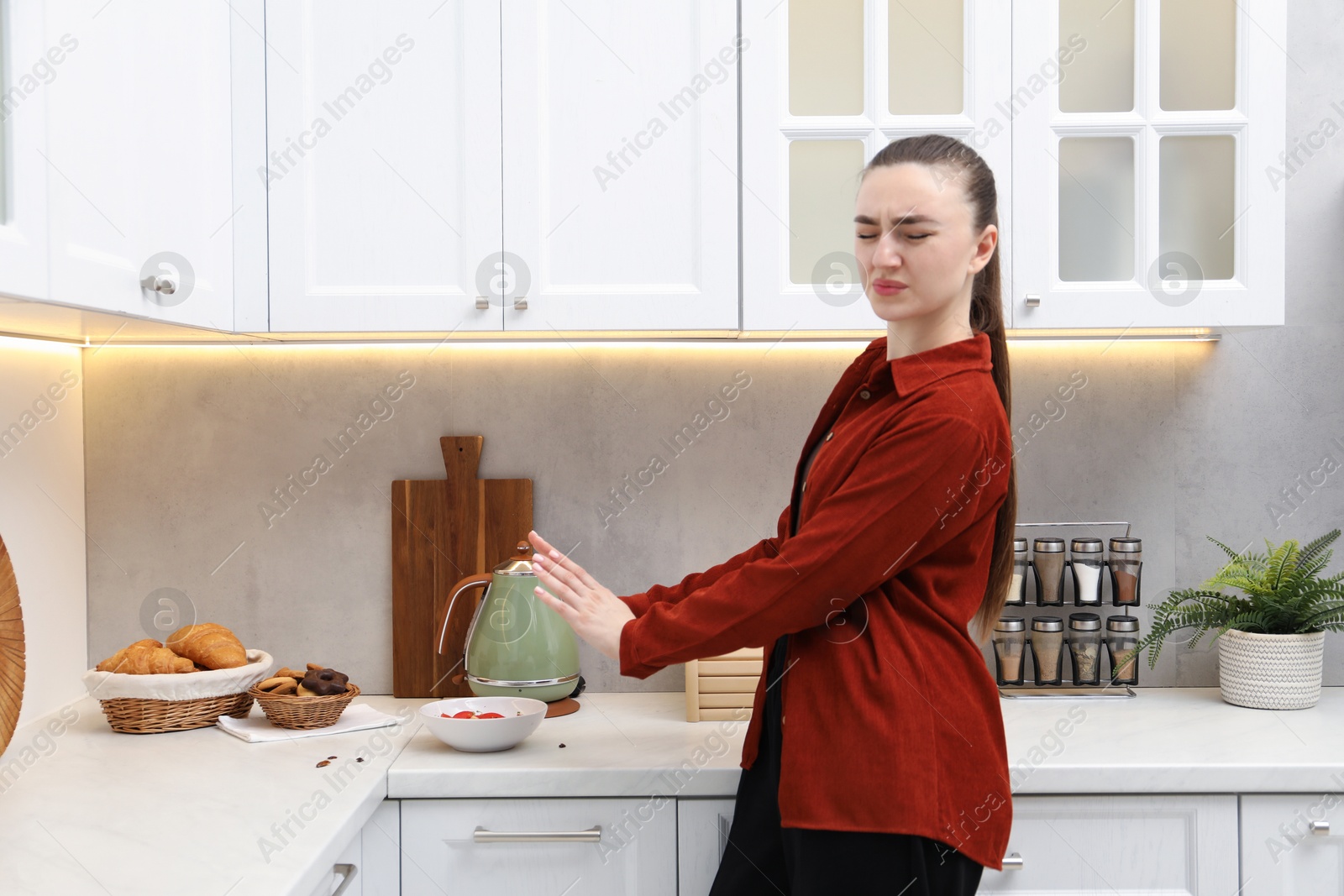 Emotional woman afraid of cockroaches in kitchen. Pest problem Photo of Emotional woman afraid of cockroaches in kitchen. Pest problem