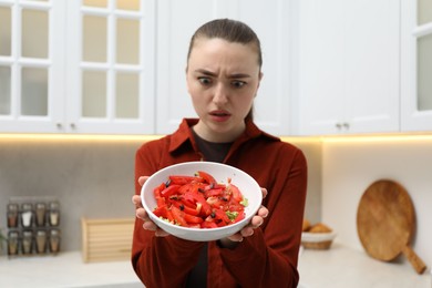 Photo of Woman holding bowl with vegetables and cockroaches in kitchen, selective focus