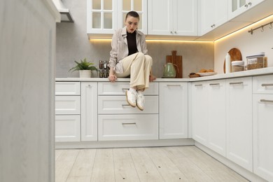 Photo of Emotional woman looking in disgust at cockroaches on floor indoors. Pest problem