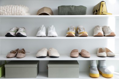 Photo of Different footwear, clothes and accessories on shelves indoors. Shoe storage