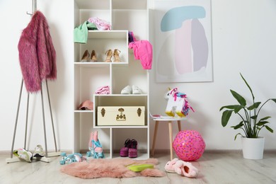 Photo of Shelving unit with different footwear, accessories and clothes indoors. Shoe storage